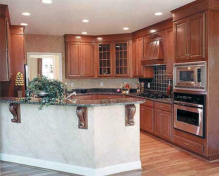 Kitchen with wood cabinets, granite countertops, large island with decorative corbels, and stainless steel appliances.