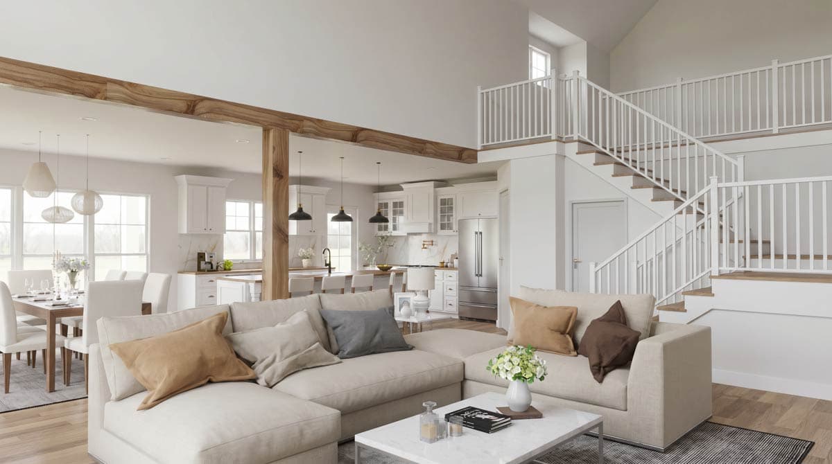 Open-concept living area with sectional sofa, dining table, and kitchen. Features vaulted ceilings, wood beams, and a two-story staircase.