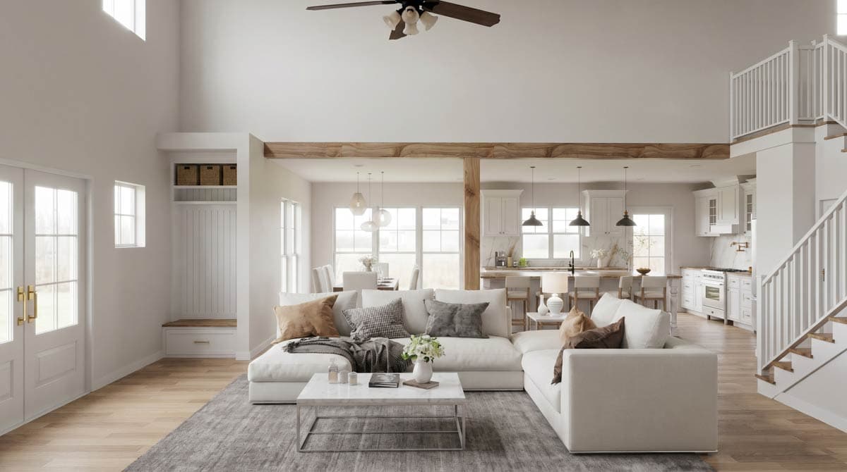 Great room with vaulted ceiling, exposed beams, large windows, fireplace, and open kitchen with island. Stairs ascend to loft.