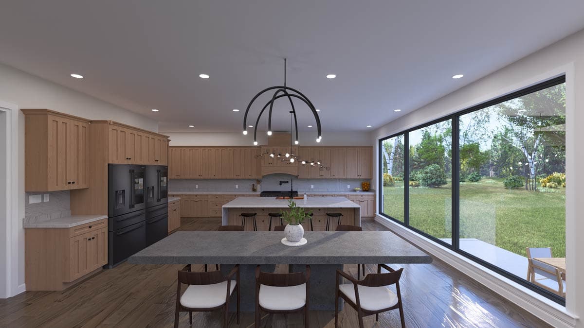 Modern kitchen with light wood cabinets, large island, dining area, and expansive wall of windows overlooking a backyard.