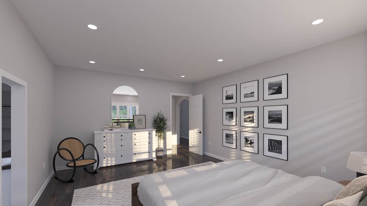 Bedroom with arched doorway, dresser with arched mirror, gallery wall, and modern chair.