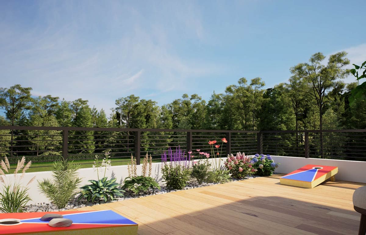 Outdoor deck with cornhole boards, landscaping, and a horizontal railing overlooking trees.