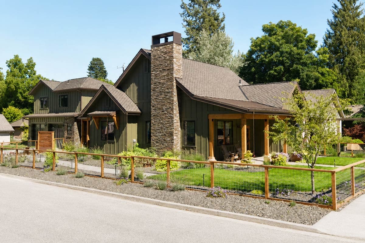 House plan exterior: Modern Farmhouse style, two stories, stone chimney, covered porch, and gables.