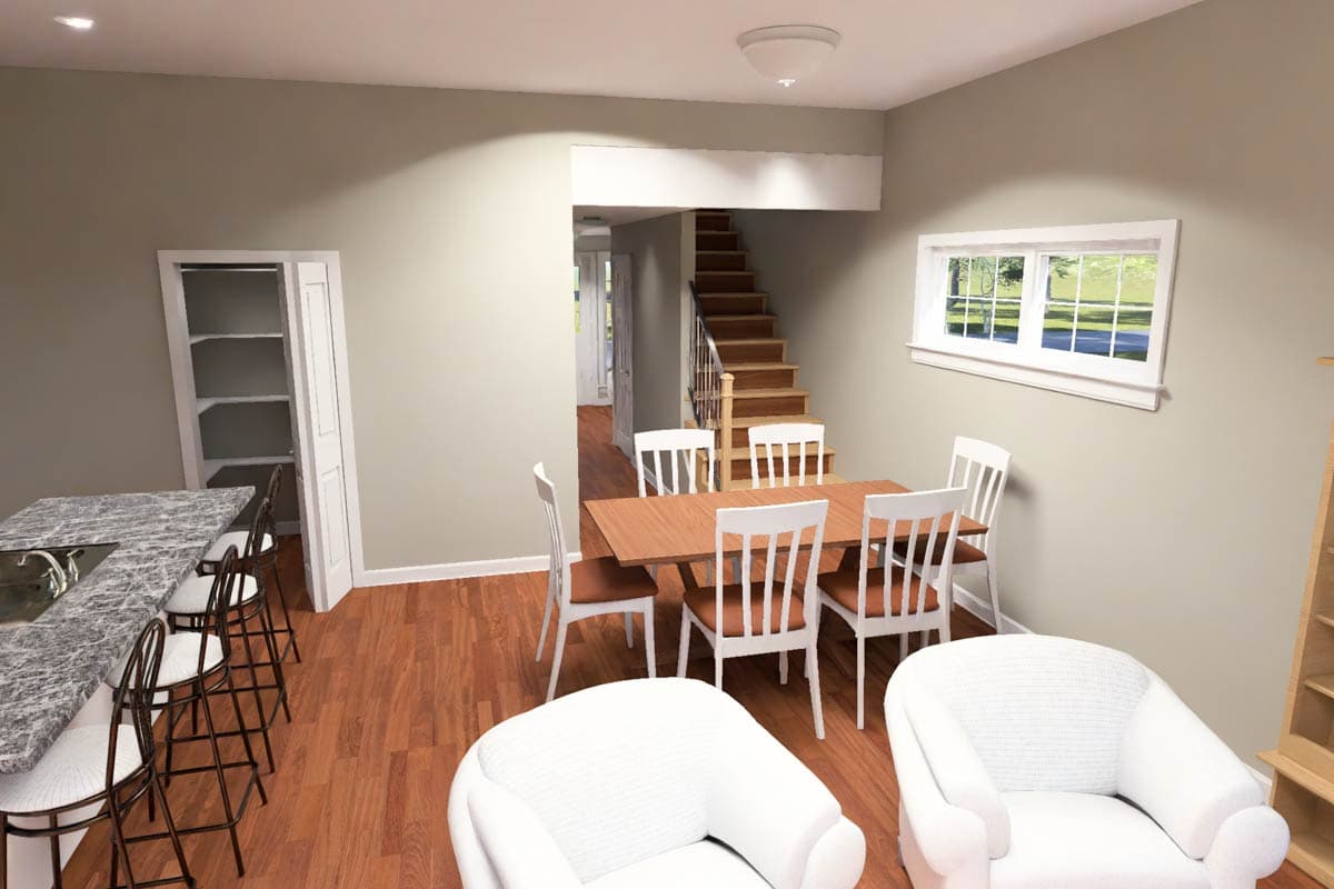 Interior view of a dining area and kitchen with island, stairs, and white chairs.