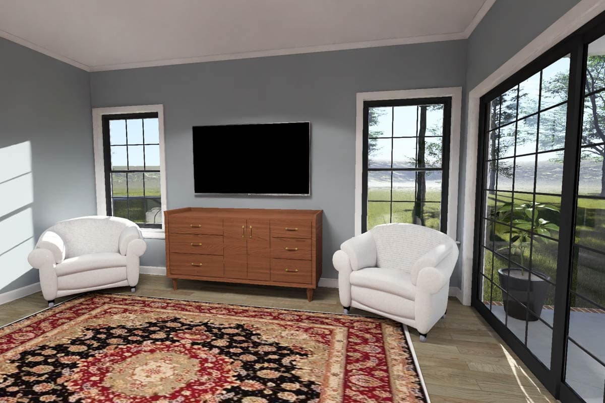 Living area with two white armchairs, a wooden dresser, a TV, and large windows overlooking a yard.