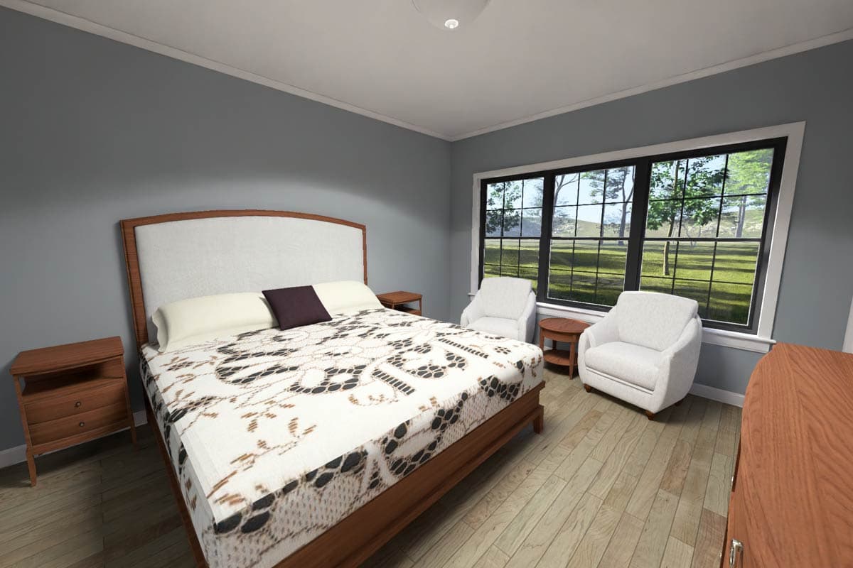 Primary bedroom with queen bed, two armchairs, bedside tables, and large window overlooking a yard.