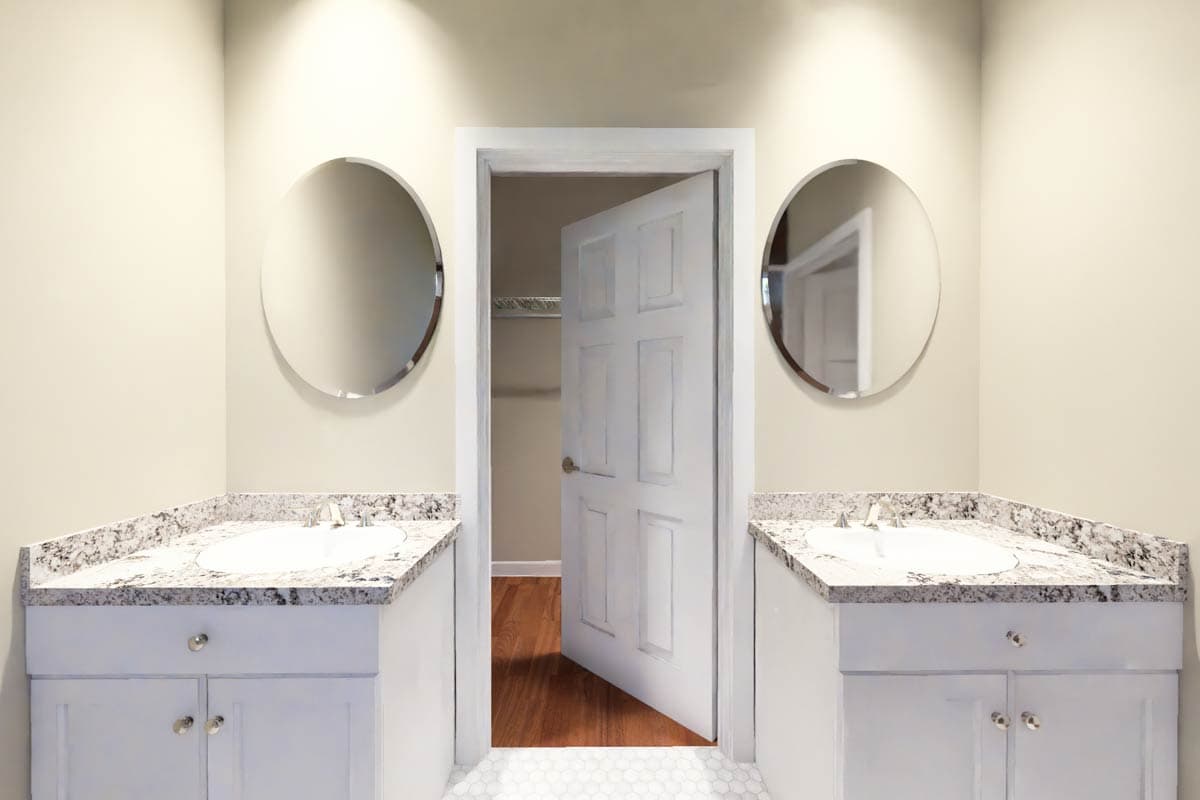 Bathroom vanity with dual sinks, granite countertops, and a doorway leading to a closet with hardwood floors.