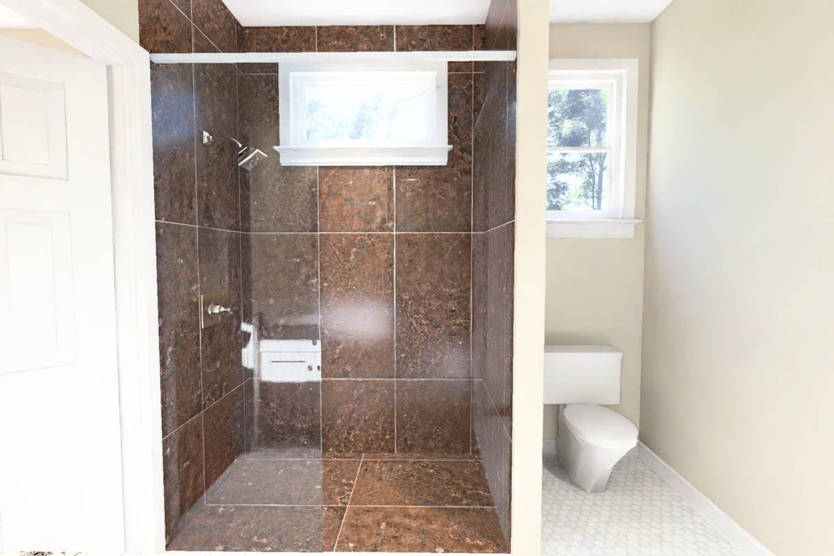 Bathroom with tiled walk-in shower, toilet, and window with white trim. Hexagonal floor tiles.