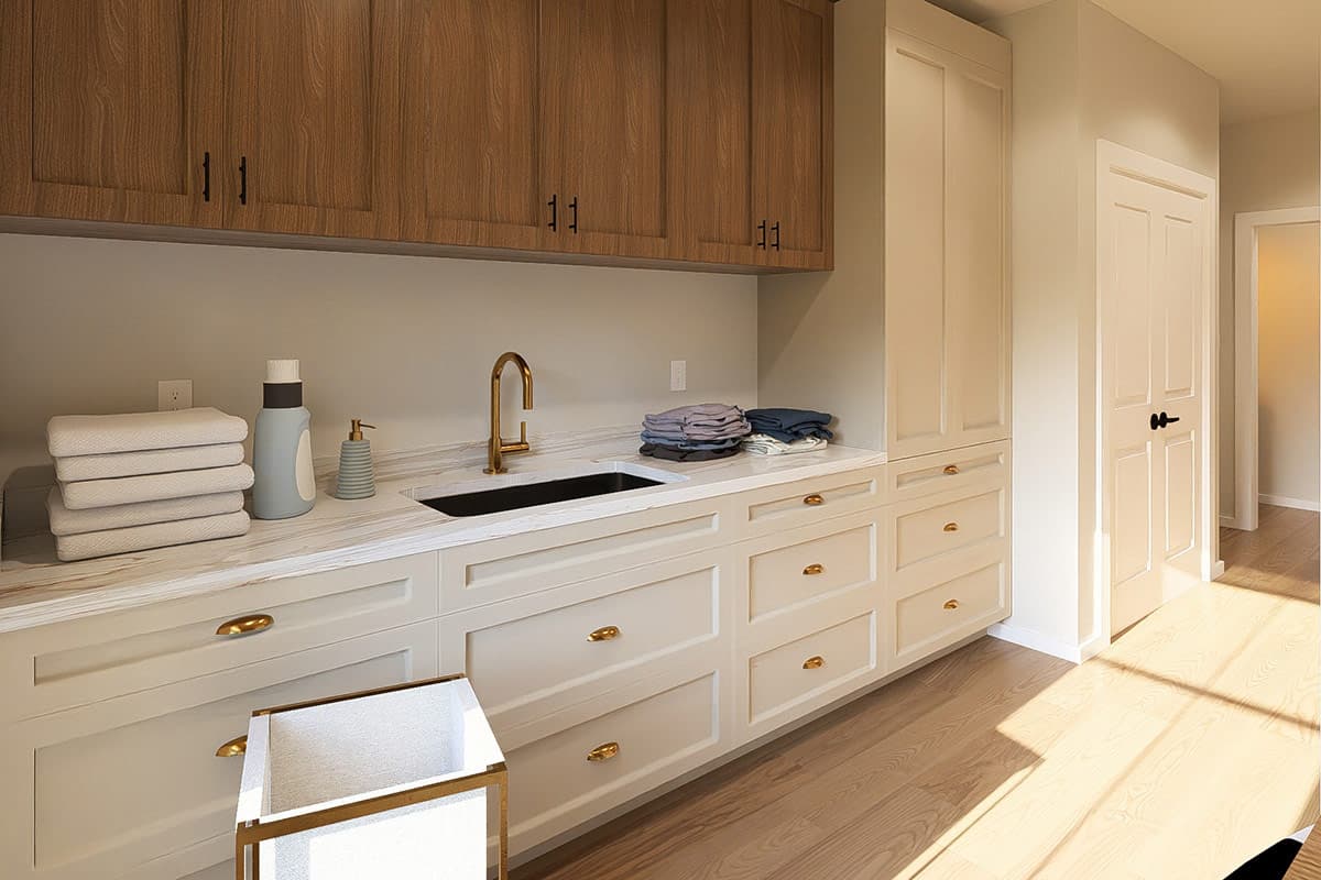 Laundry room with white cabinetry, wood upper cabinets, dark sink, and gold faucet. Includes tall storage cabinet and double doors.