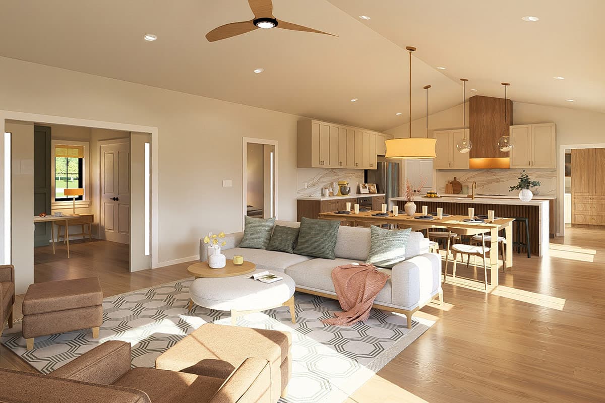 Open concept living space with vaulted ceiling showing a sectional sofa, dining table, kitchen island, and cabinetry.
