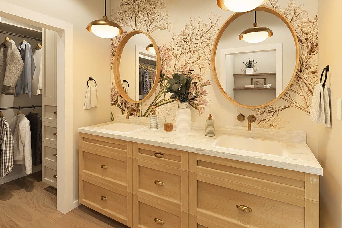 Bathroom vanity with double sinks, wood cabinetry, and floral wallpaper. Adjacent closet with clothing.