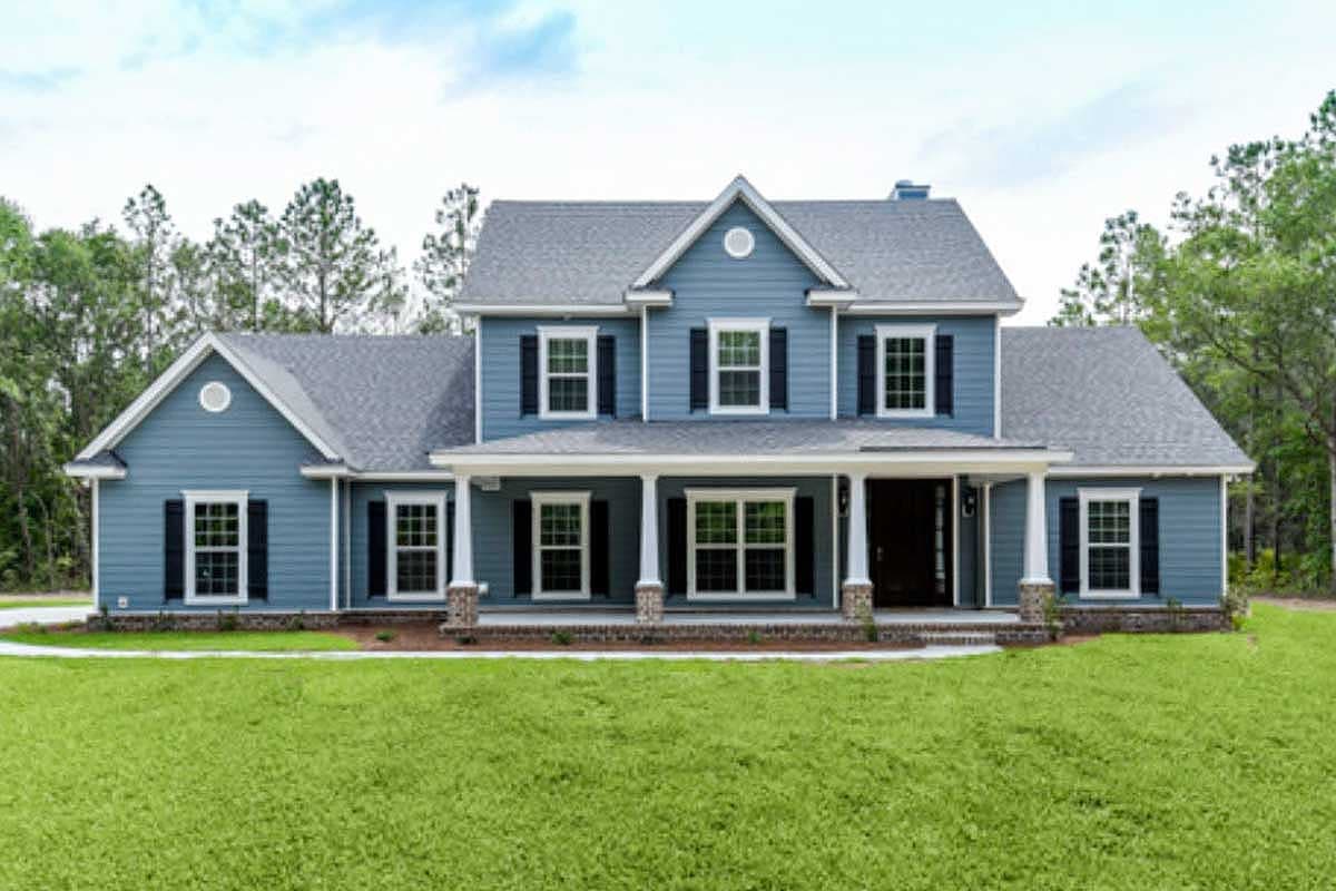 Two-story house plan exterior with a wraparound porch, multiple gables, and a prominent central dormer.