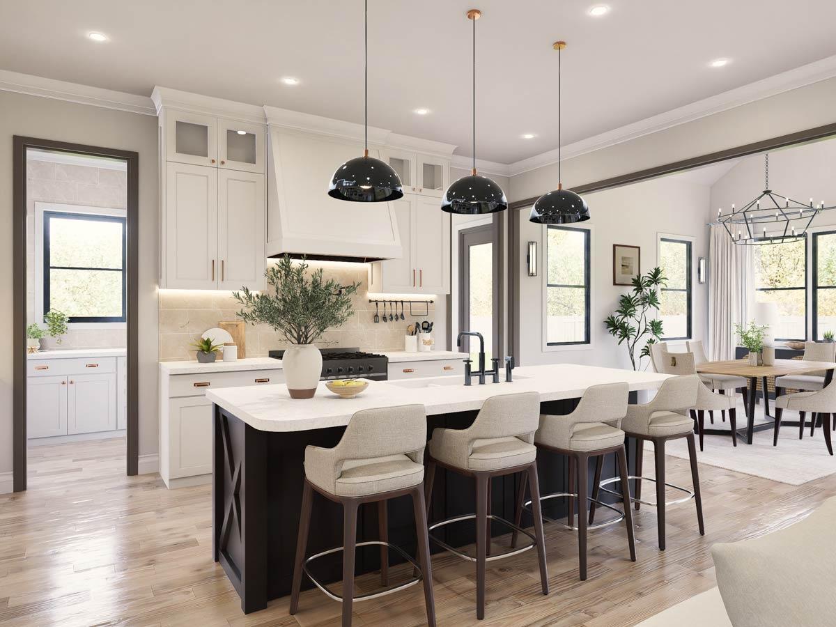 Modern kitchen with island seating, white cabinetry, range hood, and open dining area with chandelier.