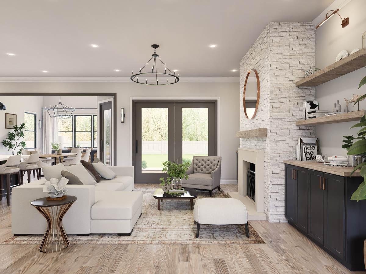 Living room with white sectional sofa, tufted armchair, stone fireplace, built-in cabinets, and adjoining dining area.