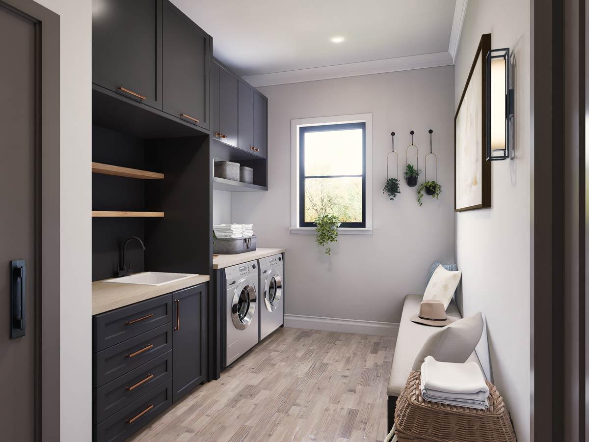 Laundry room with dark cabinetry, sink, washer, dryer, bench seating, and a window.