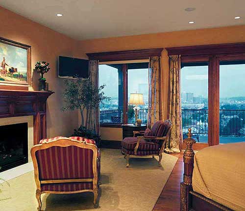 Living area with fireplace, large windows, and upholstered seating, offering city views.
