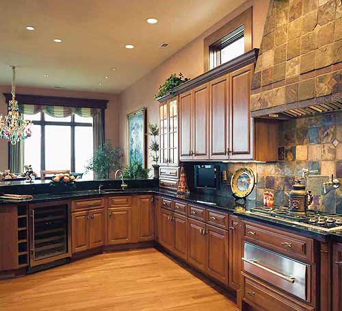 Kitchen with wood cabinetry, granite countertops, stainless steel appliances, and a stone-tiled range hood.