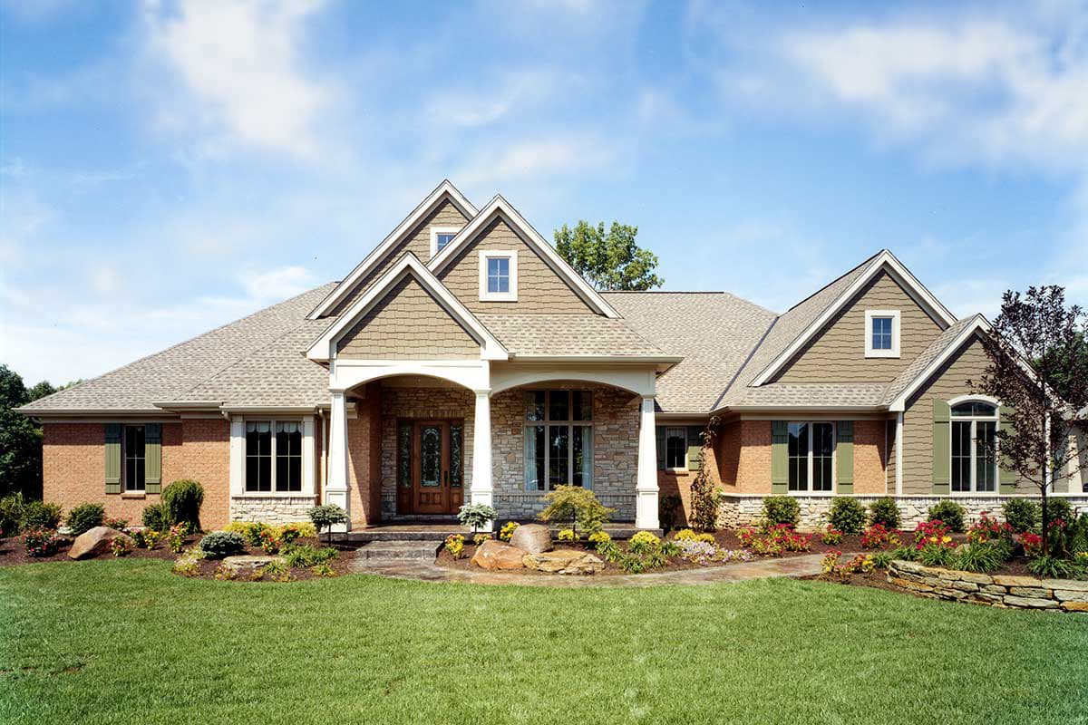 House plan exterior: Ranch style with covered entry, stone accents, brick siding, gables, and dormers.