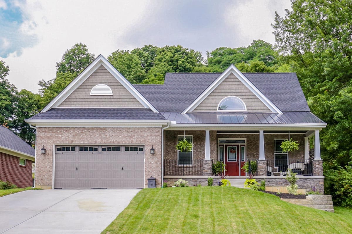 House plan exterior: Modern Farmhouse style, two-story, brick facade, gable dormer, front-entry garage, and covered porch.