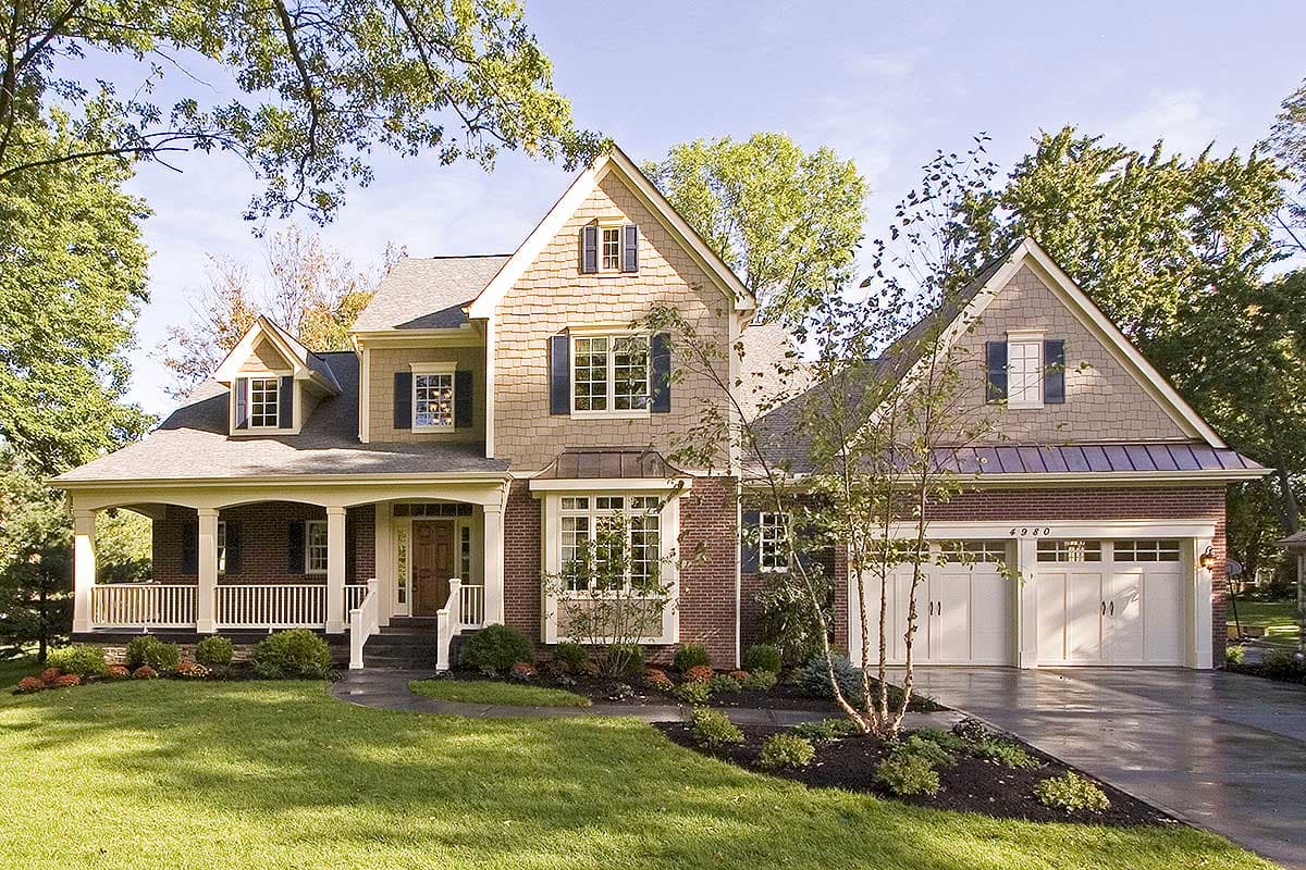 House plan exterior. Two-story with Craftsman details: front porch with columns, gabled roof, and attached garage. Brick and siding exterior.