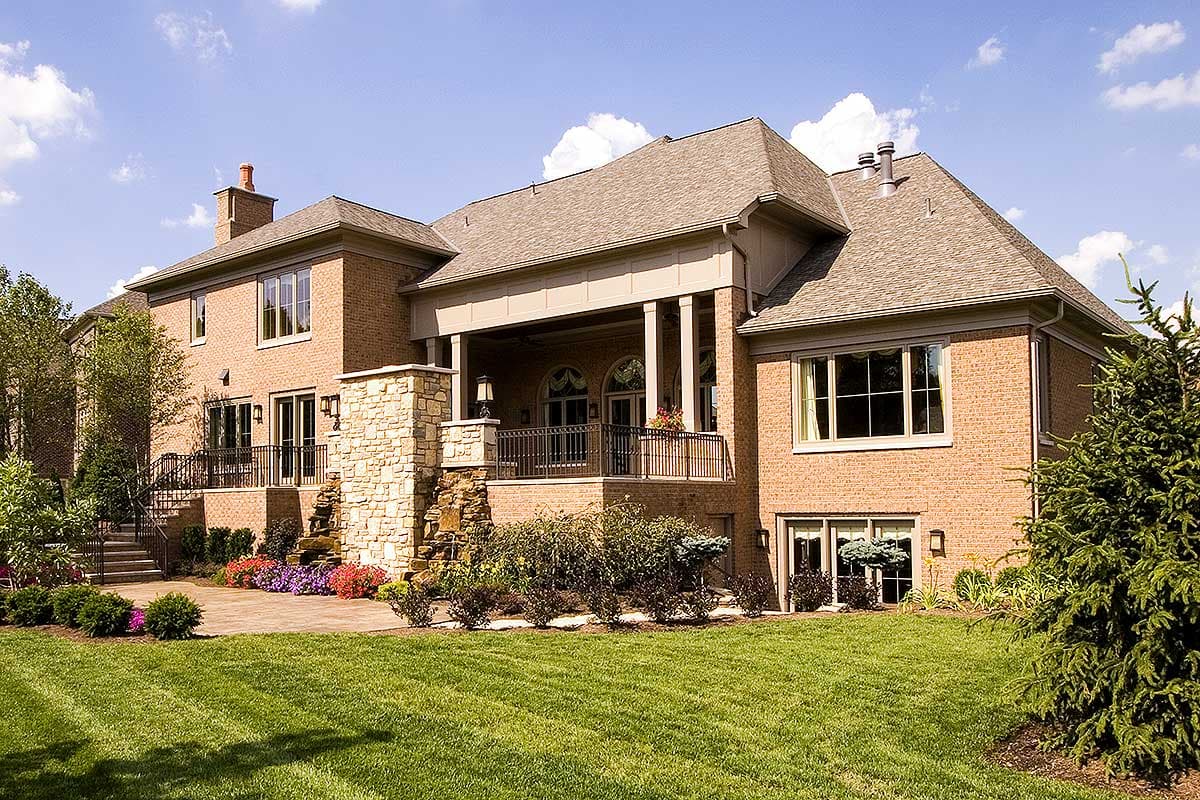 House plan exterior view of a two-story brick home with a covered porch, stone accents, and multiple gables.