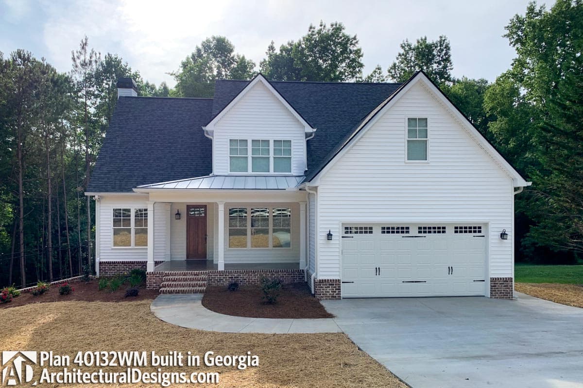 House plan exterior: Two-story Modern Farmhouse with gabled dormer, metal porch roof, and two-car side-entry garage.