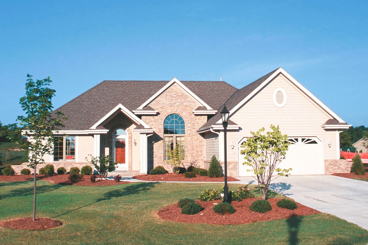 House plan exterior: Ranch style, one story, with gabled roof, arched entry, brick accents, and attached garage.