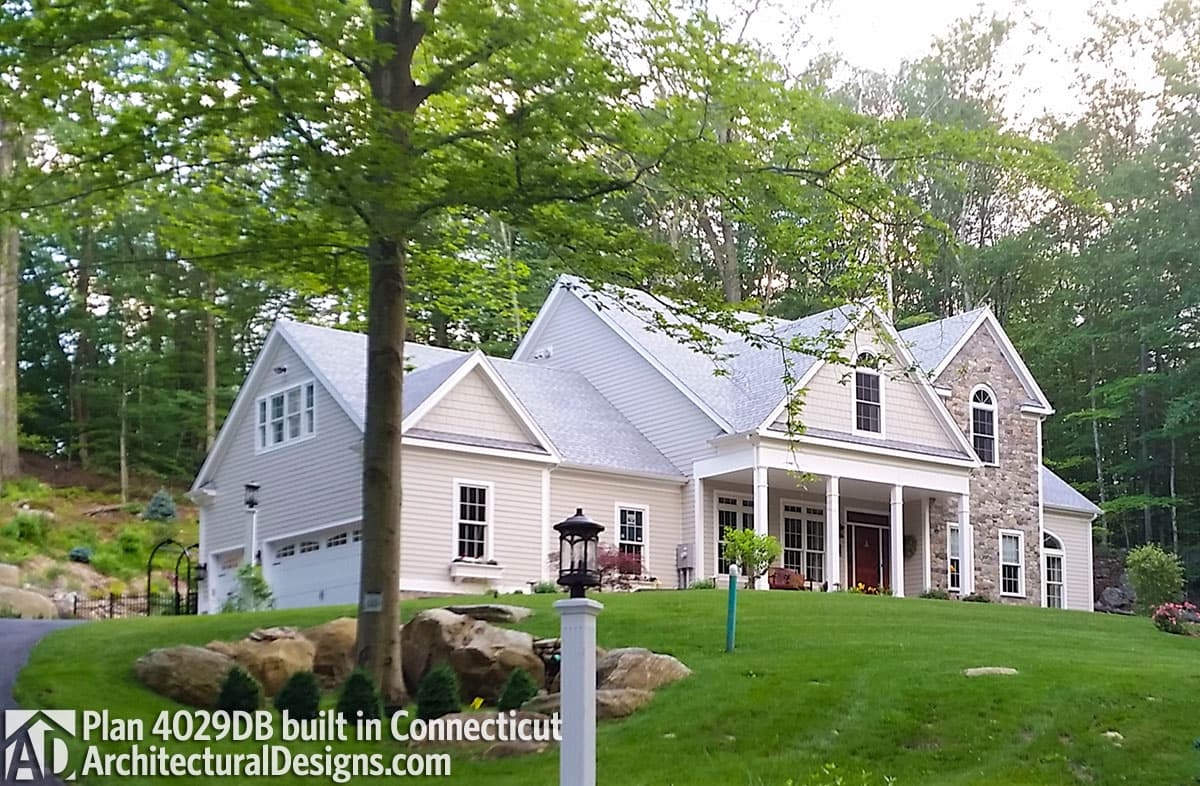 House plan exterior: Gable rooflines, covered entry porch, stone facade accents, and dormer windows.