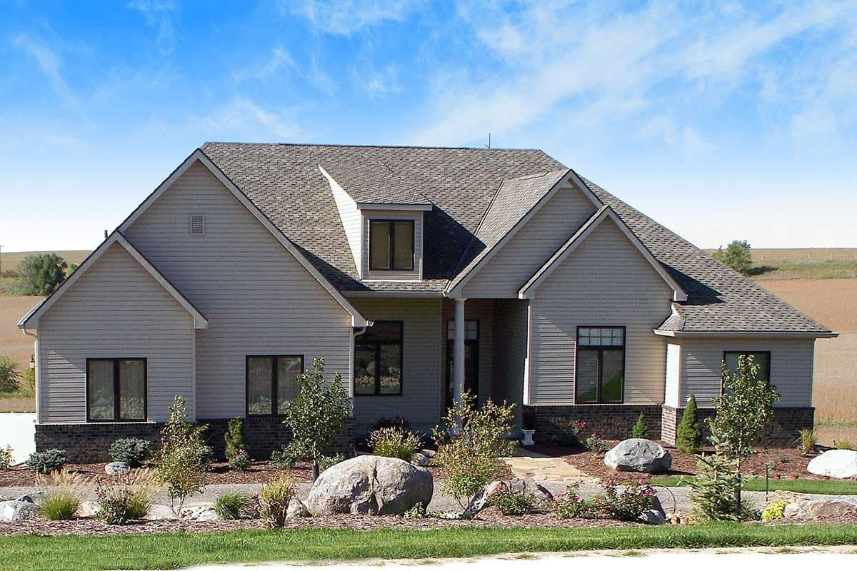 House plan exterior of a two-story home with a prominent dormer, multiple gables, and partial brick wainscoting.