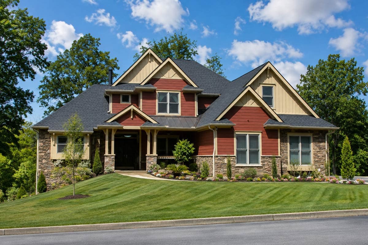 House plan exterior. Two-story Craftsman home with gabled roof, stone accents, and covered front porch.