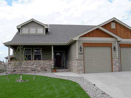 House plan exterior of a two-story home with a covered porch, stone accents, dormer with three windows, and a two-car garage.