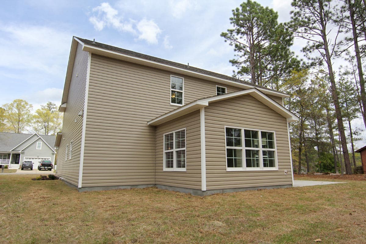 Two-story house plan exterior with tan vinyl siding, white trim, gabled roof, and multiple windows. House plan.