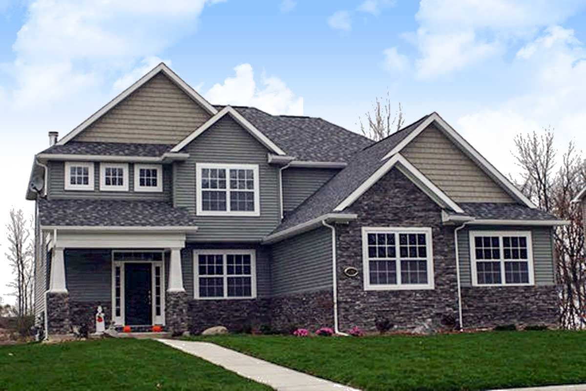 Two-story house plan exterior with stone and siding, a covered porch with columns, and multiple gables.