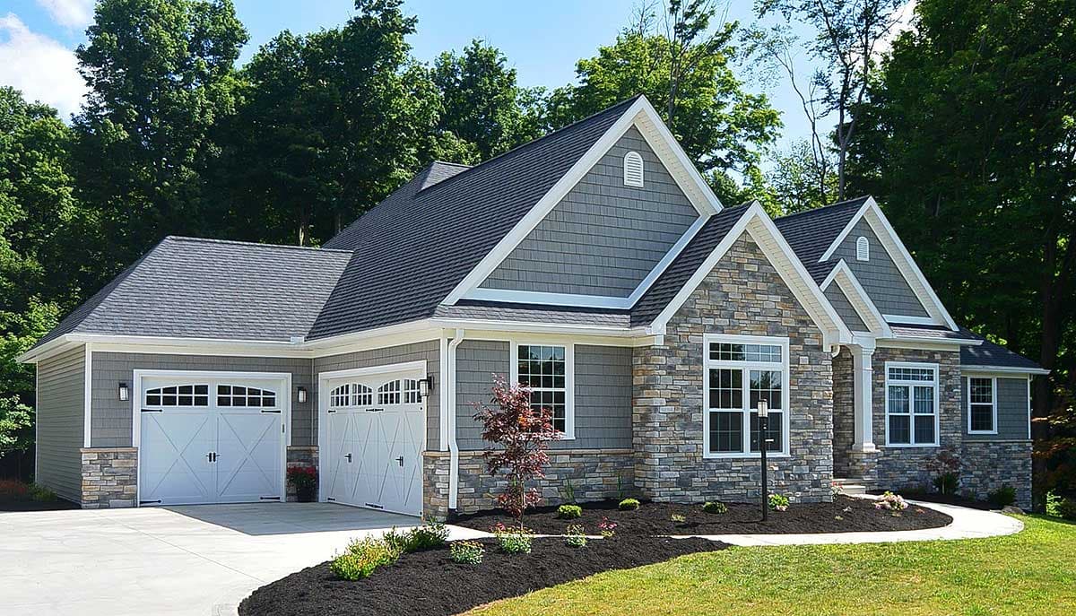 House plan exterior: Ranch style, stone and shingle siding, a three-car garage, and prominent gables.