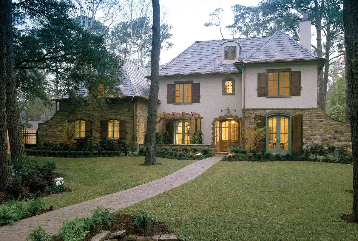 House plan exterior: Two-story European-style home with stone accents, arched entryway, slate roof, and dormer.