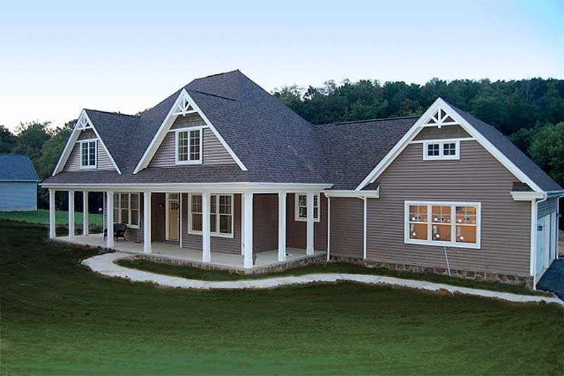 House plan exterior showing a one-story modern farmhouse with a wraparound porch, gables with decorative trim, and dormers.