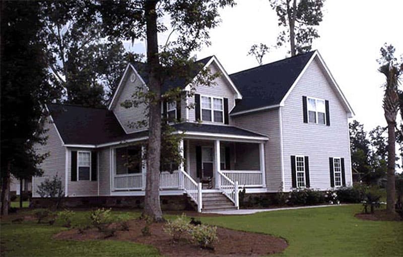 House plan exterior: Two-story home with a covered front porch, gables, and a side-facing garage.