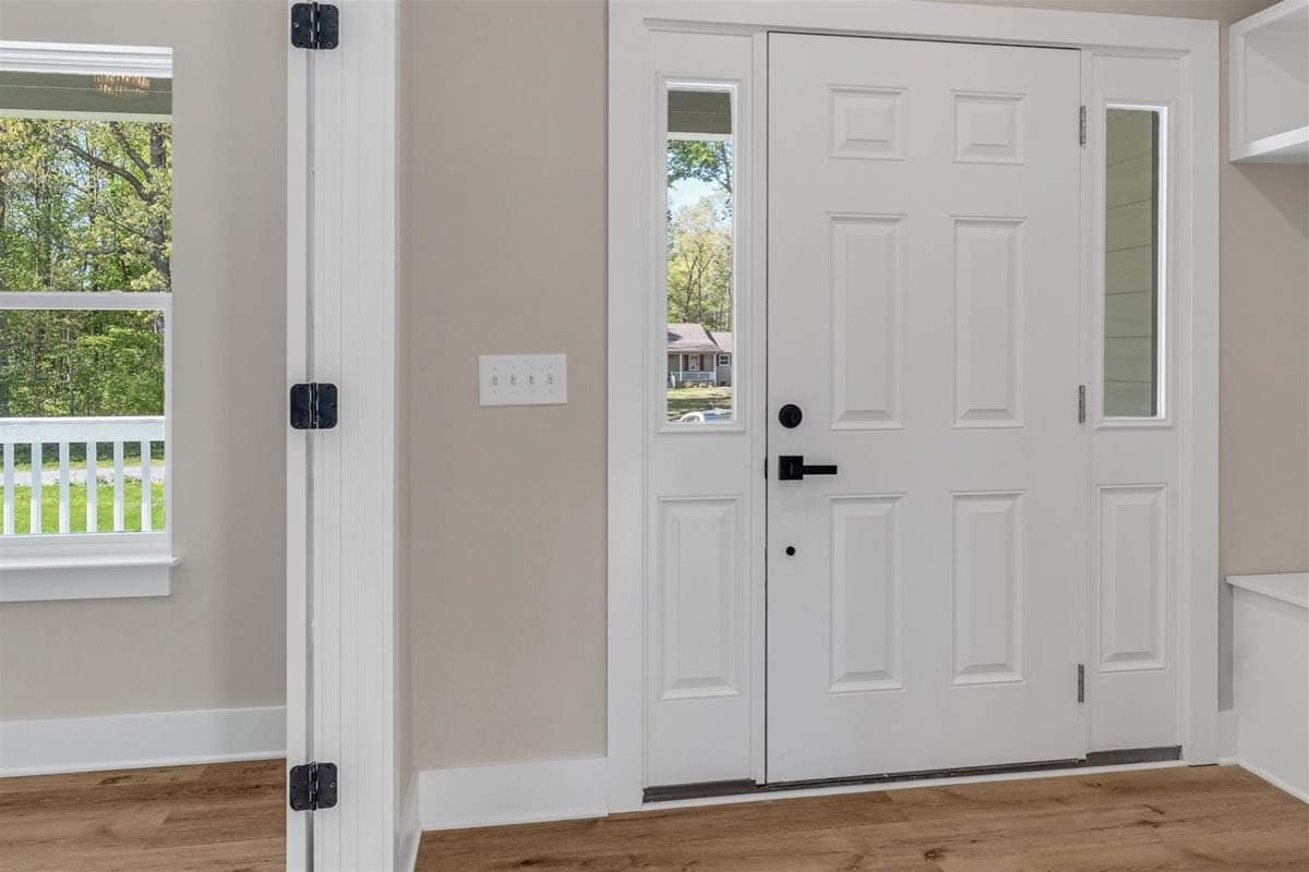 House plan exterior, white six-panel door with transom and sidelight windows, black hardware.