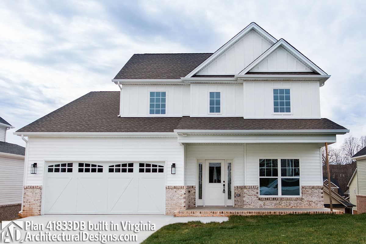 House plan exterior: Two-story Modern Farmhouse with a two-car side-entry garage, white board-and-batten siding, and brick accents.