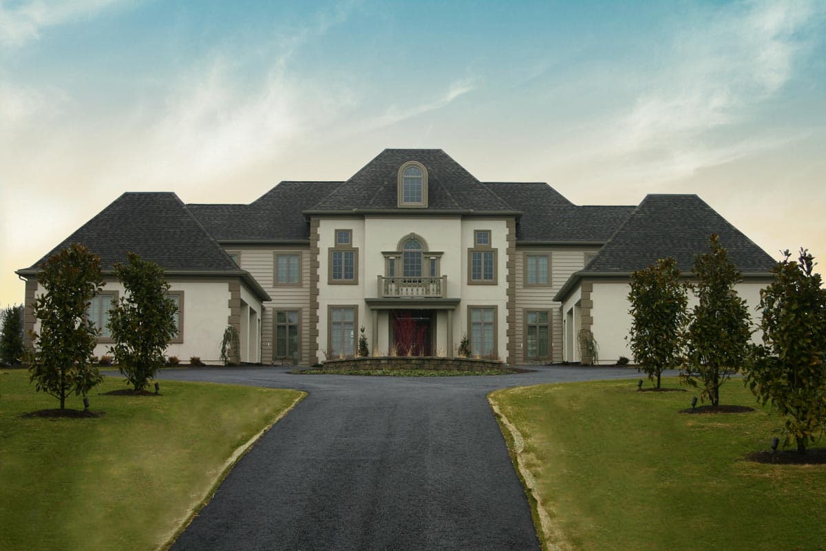 House plan exterior: Two-story symmetrical facade with central arched entryway, balcony, dormer, and attached garages.
