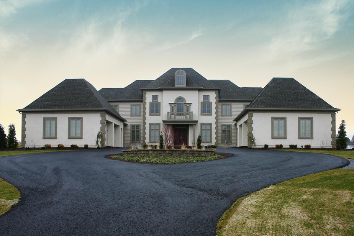 Two-story house plan exterior with attached garages, hipped roofs, central Palladian window, and balcony.