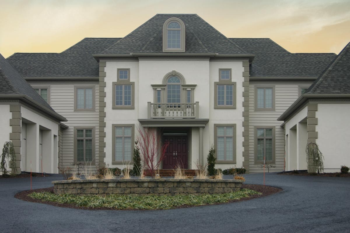 House plan exterior featuring a stucco facade, multiple gables, arched dormer, second-story balcony, and attached garages.