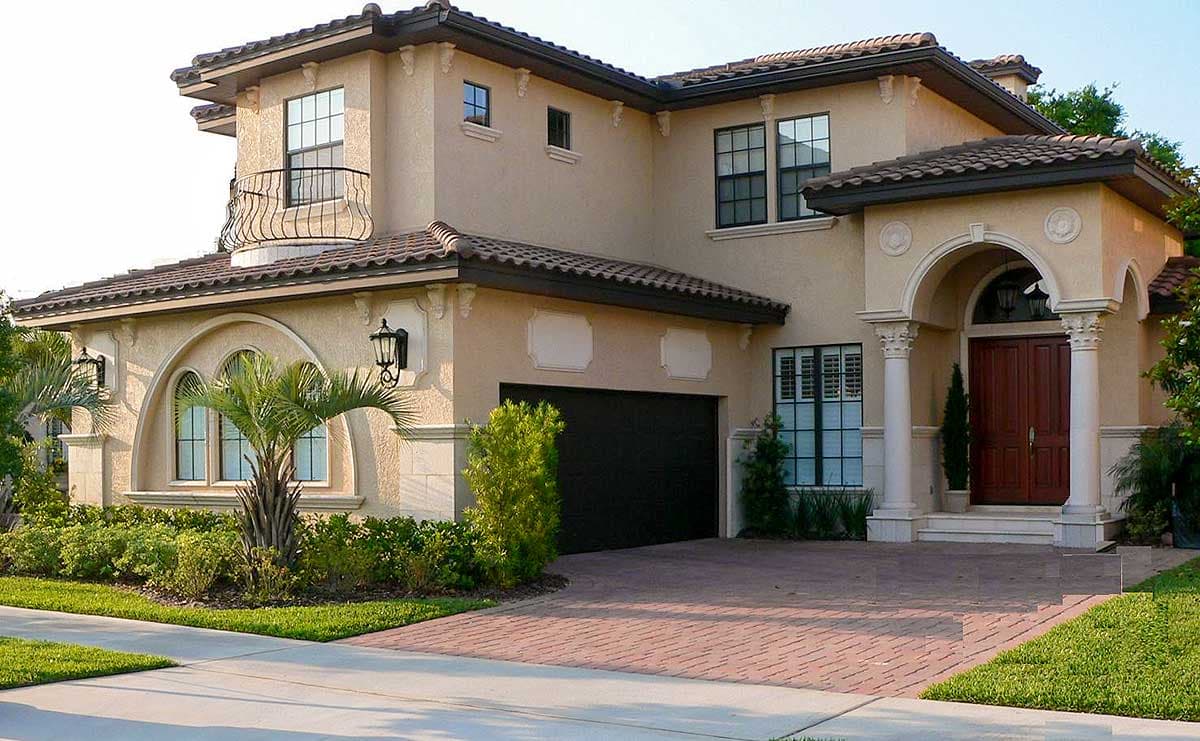 Two-story Mediterranean style house plan exterior with arched windows, balcony, tiled roof, and ornate entrance.
