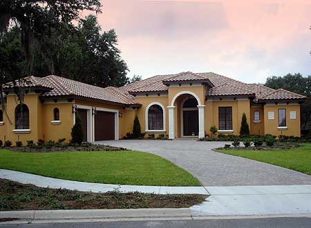 House plan exterior: single-story Mediterranean style home with arched entryway, tile roof, and attached garage.