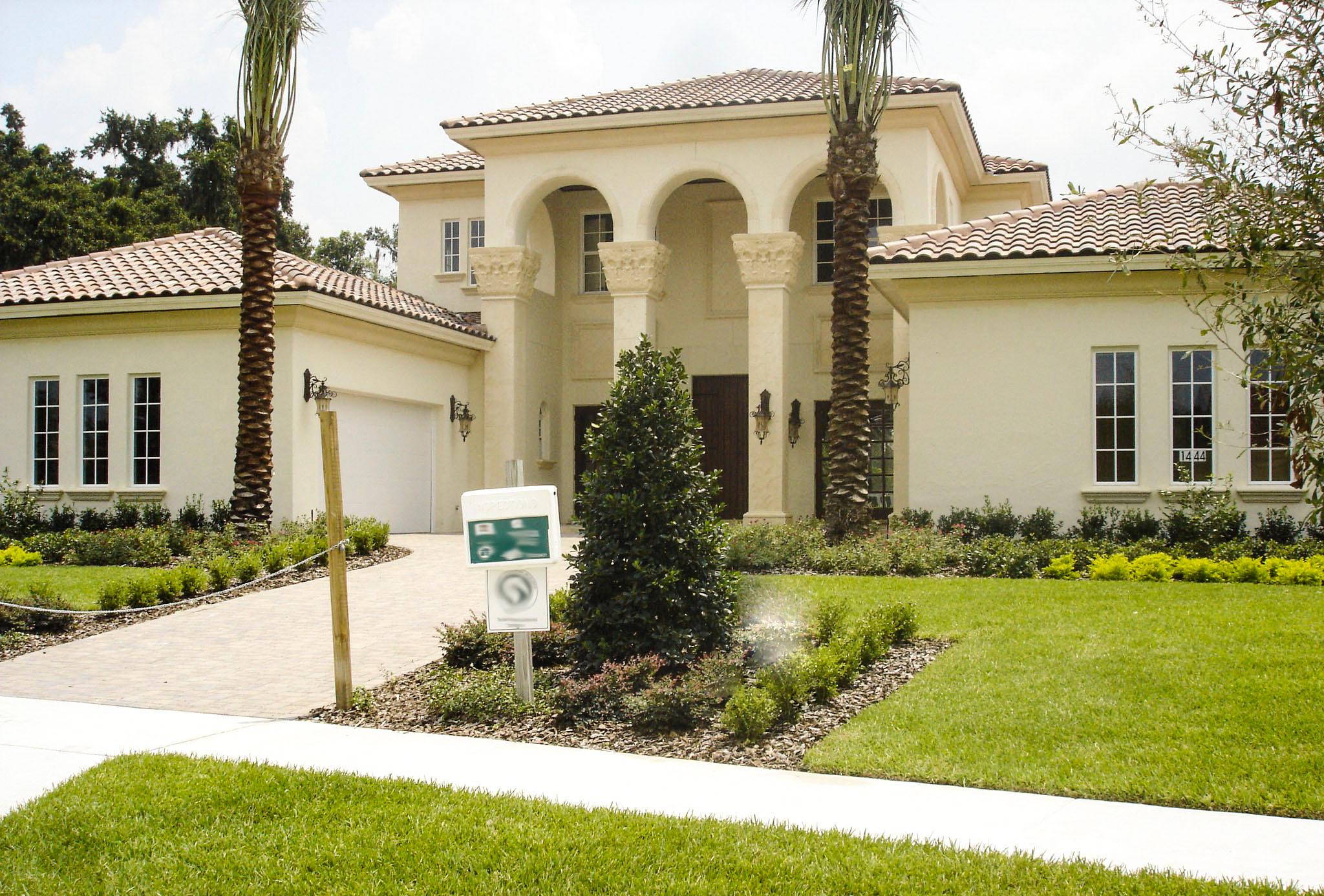 House plan exterior. Two-story Mediterranean style with arched entryway, tile roof, and garage. Features include columns, and multiple windows.