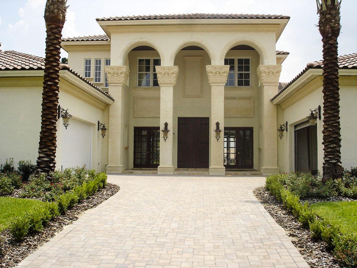 House plan exterior with arched entry, columns, tile roof, and two-car garage.