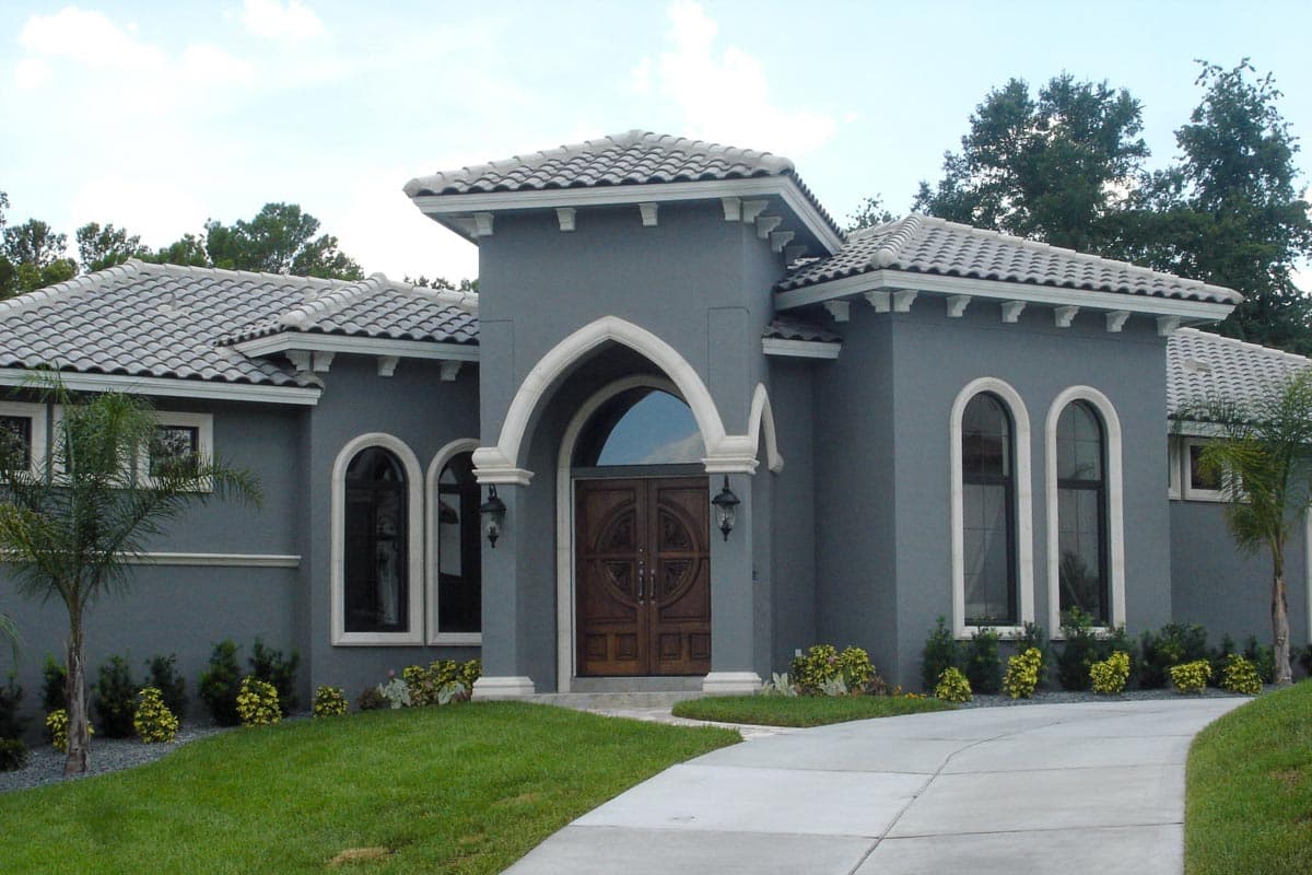 House plan exterior: Mediterranean style, one-story with arched entryway, double doors, tile roof, and arched windows.
