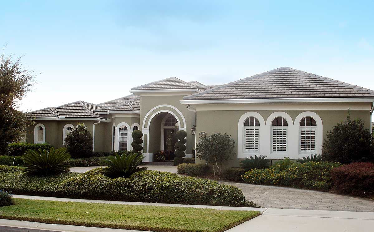 House plan exterior: One-story Mediterranean style with arched entryway, arched windows, and tiled roof.