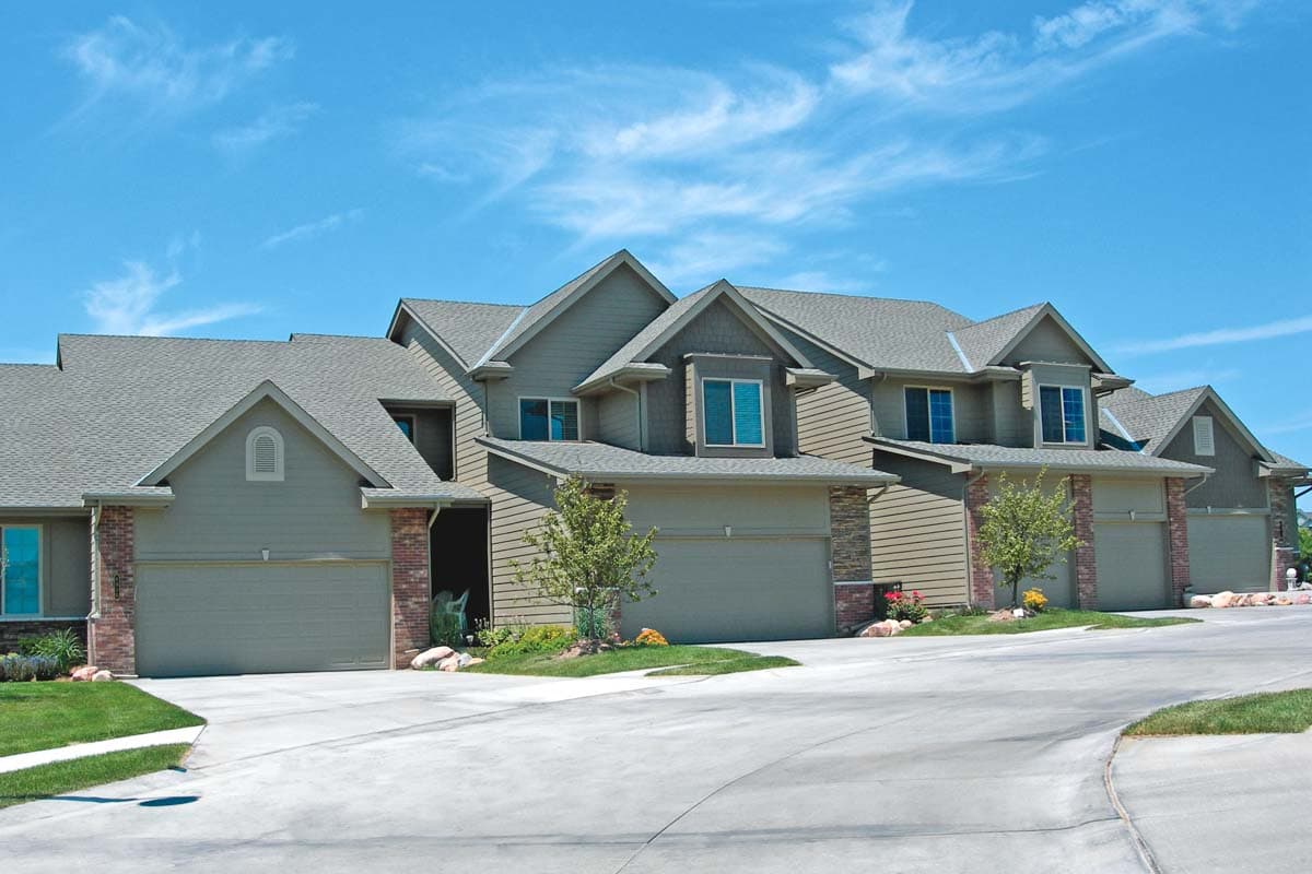 Townhouse exterior with multiple garages, varied gables, and stone accents.
