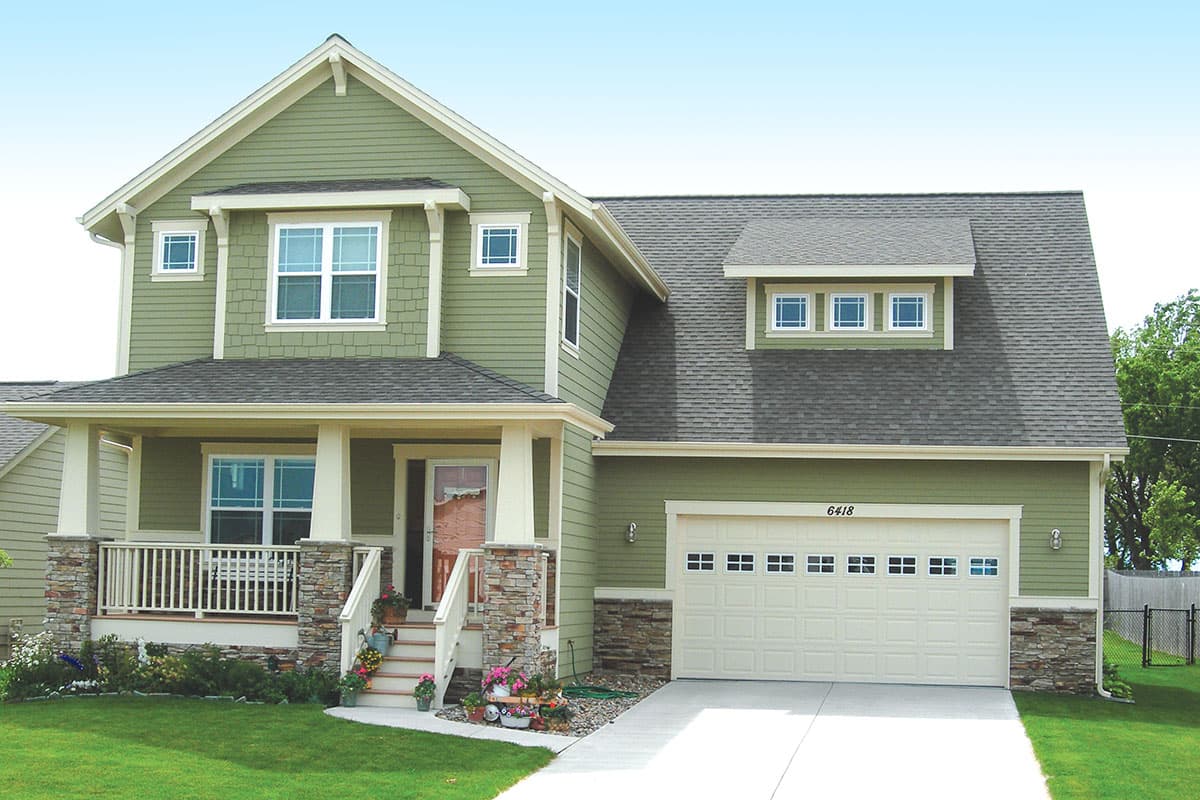 House plan exterior: Two-story home with front porch, stone accents, dormer with three windows, and attached two-car garage.